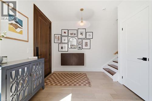 Light wood-finish flooring, white walls, and a wood-panel entry door - 57 Terrace Hill Street, Brantford, ON 