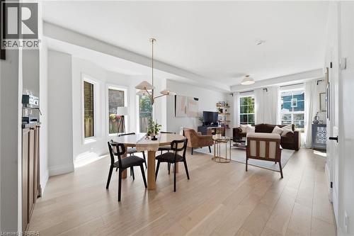Open-concept living space with light wood-finish flooring, recessed lighting, a bay window, and a modern chandelier - 57 Terrace Hill Street, Brantford, ON 