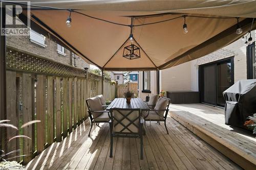 Expansive wood deck with a built-in privacy fence, featuring a large overhead canopy with integrated lighting - 57 Terrace Hill Street, Brantford, ON 