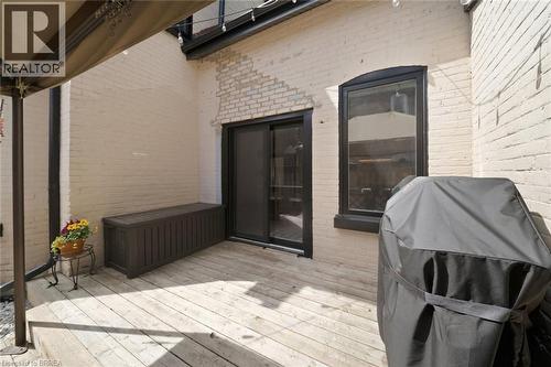 Deck area featuring wood-finish flooring and painted brick walls - 57 Terrace Hill Street, Brantford, ON 