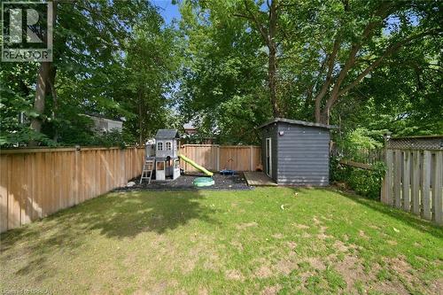 Manicured lawn with a privacy fence, wood garden shed, and mature trees - 57 Terrace Hill Street, Brantford, ON 