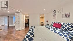 Recessed lighting, wood-finish flooring, white paneled doors, and a built-in closet with shelving - 
