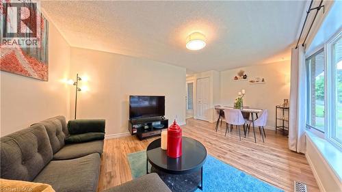 Wood-finish flooring throughout, bay window with multiple panes, recessed ceiling light fixture, and a built-in closet with bifold doors - 380 Grangewood Drive, Waterloo, ON 