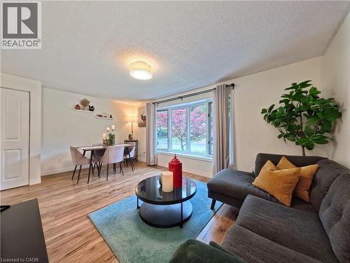 Wood-finish flooring throughout, featuring a curved bay window, a ceiling-mounted light fixture, and a built-in wall shelf - 380 Grangewood Drive, Waterloo, ON 