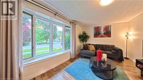 Expansive bay window, wood-finish flooring, recessed ceiling light fixture, neutral wall paint, and white trim - 380 Grangewood Drive, Waterloo, ON 