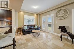Spacious living area featuring large format tile flooring and recessed lighting - 