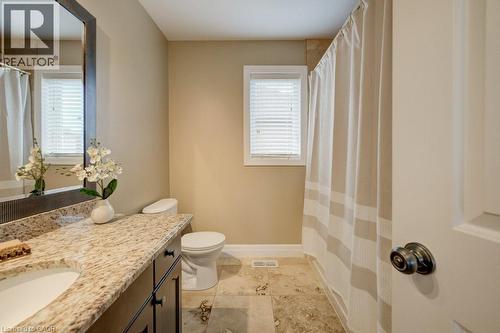 Bathroom featuring a single vanity with a granite countertop, undermount sink, and dark wood cabinetry - 300 Watervale Crescent, Kitchener, ON 