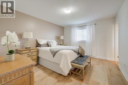 Bedroom featuring light wood-finish flooring, a window with horizontal blinds, and a neutral color palette - 300 Watervale Crescent, Kitchener, ON 