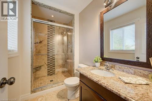 Glass-enclosed shower with a textured stone tile surround and integrated bench - 300 Watervale Crescent, Kitchener, ON 