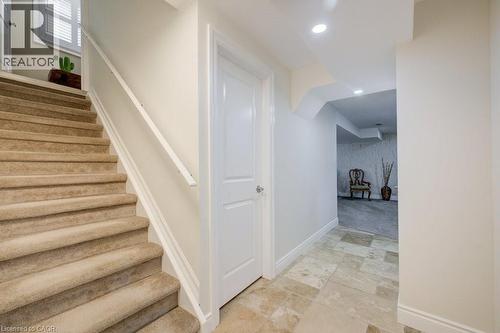Carpeted staircase with white handrail and baseboards - 300 Watervale Crescent, Kitchener, ON 