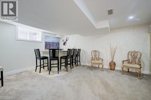 Recessed lighting illuminates a built-in bar with countertop, complemented by light-toned wall finishes and a window with blinds - 300 Watervale Crescent, Kitchener, ON 