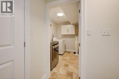 Laundry area featuring tile flooring, built-in upper cabinetry, and a circular overhead light fixture - 300 Watervale Crescent, Kitchener, ON 