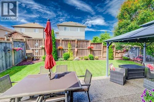 Expansive backyard featuring a manicured lawn, established landscaping, and a privacy fence - 300 Watervale Crescent, Kitchener, ON 