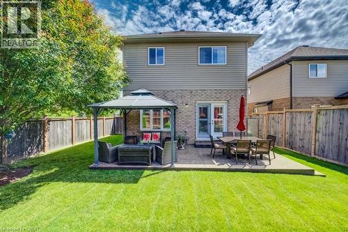 Expansive backyard featuring a manicured lawn, a concrete patio, and a privacy fence - 300 Watervale Crescent, Kitchener, ON 