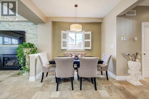 Open-concept dining area featuring tile flooring, a window with interior shutters, and a chandelier - 300 Watervale Crescent, Kitchener, ON 