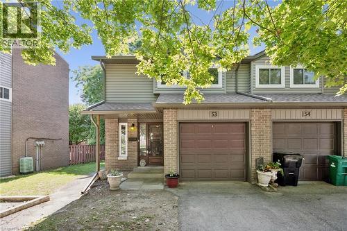 Brick and siding exterior with individual garage, covered entry, and front door with glass insert - 46 Cedarwoods Crescent Unit# 53, Kitchener, ON - Outdoor With Exterior