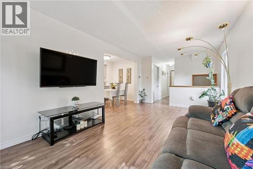 Wood-finish flooring throughout, white wall finishes, and a partial wall with a wood-framed opening - 46 Cedarwoods Crescent Unit# 53, Kitchener, ON - Indoor Photo Showing Living Room