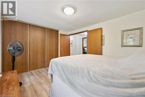 Recessed lighting fixture, light wood-finish flooring, wood-toned sliding closet doors, and wood-toned interior doors - 46 Cedarwoods Crescent Unit# 53, Kitchener, ON - Indoor Photo Showing Bedroom