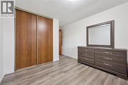 Wood-finish flooring with a neutral white wall color, featuring a built-in closet with sliding wood-finish doors - 