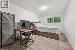 Wood-finish flooring, white walls, and a window with exterior visibility - 