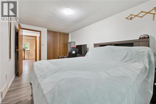 Wood-finish flooring, white painted walls, and wood-panel sliding closet doors - 46 Cedarwoods Crescent Unit# 53, Kitchener, ON - Indoor Photo Showing Bedroom