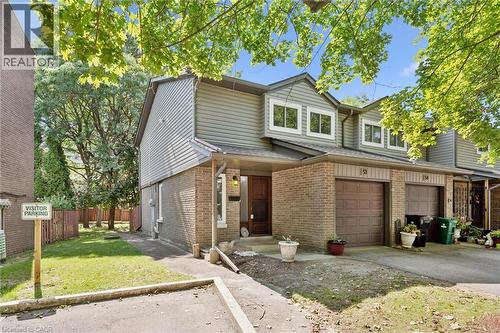 Brick and siding exterior featuring an integrated garage, front entry, and multiple windows - 46 Cedarwoods Crescent Unit# 53, Kitchener, ON - Outdoor