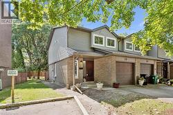 Brick and siding exterior featuring an integrated garage, front entry, and multiple windows - 