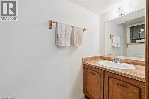 Wood-finish vanity with an integrated sink and reflective surface - 46 Cedarwoods Crescent Unit# 53, Kitchener, ON - Indoor Photo Showing Bathroom