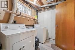 Functional laundry area featuring a utility sink, a window, and wood-finish flooring - 