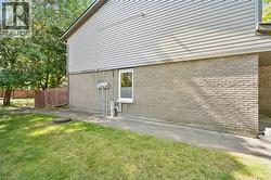 Exterior featuring light gray siding and brick lower level - 