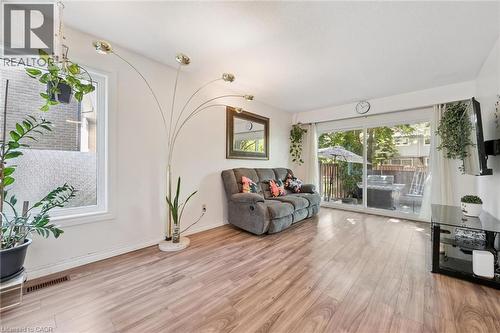 Wood-finish flooring, ample natural light from large windows, and sliding glass doors leading to an outdoor space - 46 Cedarwoods Crescent Unit# 53, Kitchener, ON - Indoor Photo Showing Living Room