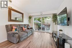 Wood-finish flooring, sliding glass patio doors, and a mounted overhead light fixture - 