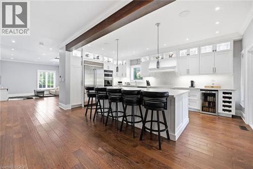 Gourmet kitchen with white cabinetry, stainless steel appliances, a beverage refrigerator, and a central island with counter seating - 2312 Ridgeview Court, Burlington, ON - Indoor Photo Showing Kitchen With Upgraded Kitchen
