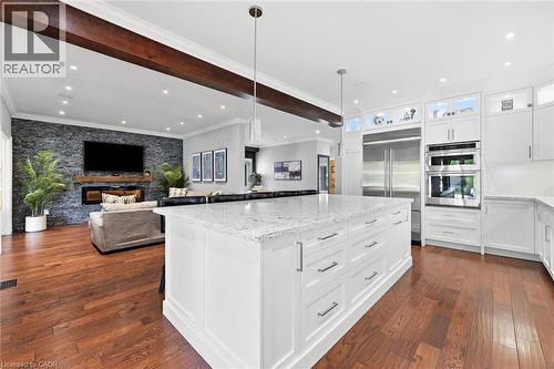 Spacious kitchen featuring a large island with a light-colored countertop, white cabinetry with stainless steel hardware, and stainless steel appliances - 2312 Ridgeview Court, Burlington, ON - Indoor Photo Showing Kitchen With Stainless Steel Kitchen With Upgraded Kitchen