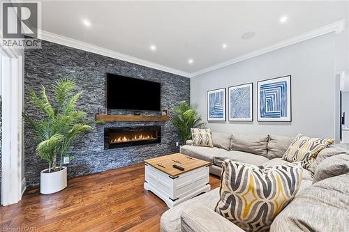 Accent wall featuring stacked stone and a built-in linear fireplace with a wood-finish mantel - 2312 Ridgeview Court, Burlington, ON - Indoor Photo Showing Living Room With Fireplace