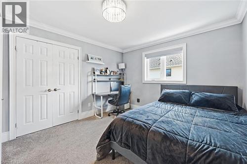 Light gray wall paint, crown molding, double pane window, plush carpet flooring, and a crystal-style flush mount ceiling light - 2312 Ridgeview Court, Burlington, ON - Indoor Photo Showing Bedroom