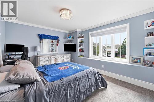 Window with white trim, built-in shelving, crown molding, and a flush mount ceiling light fixture - 2312 Ridgeview Court, Burlington, ON - Indoor Photo Showing Bedroom