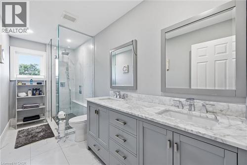 Dual vanity with stone countertop, frameless glass shower enclosure, recessed lighting, and a transom window - 2312 Ridgeview Court, Burlington, ON - Indoor Photo Showing Bathroom