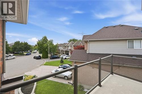 Balcony with glass panel railing and metal framework overlooking a residential street with paved driveways and manicured lawns - 2312 Ridgeview Court, Burlington, ON - Outdoor With Exterior