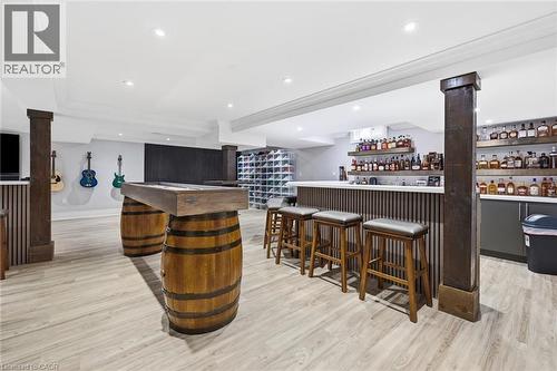Custom bar area featuring slat paneling and a light-toned countertop, wood-finish flooring, recessed lighting, and built-in shelving - 2312 Ridgeview Court, Burlington, ON - Indoor Photo Showing Other Room