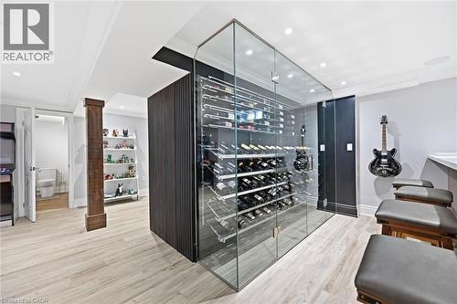 Glass-enclosed wine storage system, recessed lighting, wood-finish flooring, and a built-in counter with seating - 2312 Ridgeview Court, Burlington, ON - Indoor Photo Showing Other Room