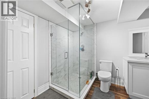 Glass-enclosed shower with marble-finish tile, vanity with undermount sink, and wood-finish flooring - 2312 Ridgeview Court, Burlington, ON - Indoor Photo Showing Bathroom