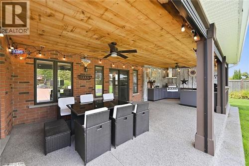 Covered patio featuring a wood-finish ceiling, brick exterior wall, a ceiling fan, and an outdoor kitchen with a built-in grill - 2312 Ridgeview Court, Burlington, ON -  With Exterior