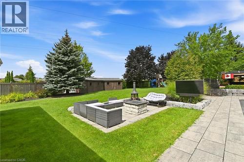 Expansive backyard featuring a stone paver patio, integrated fire pit, and a detached storage shed - 2312 Ridgeview Court, Burlington, ON - Outdoor With Backyard