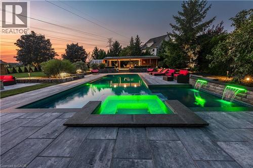 Expansive pool deck with large format pavers, a rectangular swimming pool, and an integrated hot tub - 2312 Ridgeview Court, Burlington, ON - Outdoor With In Ground Pool