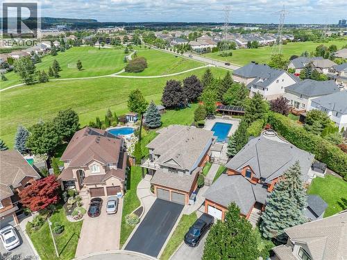 Residential property featuring an inground swimming pool, manicured lawn, and mature trees - 2312 Ridgeview Court, Burlington, ON - Outdoor With View