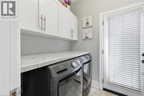 White shaker-style cabinetry with brushed nickel hardware, light-toned countertop, and a white exterior door with privacy blinds - 2312 Ridgeview Court, Burlington, ON - Indoor Photo Showing Laundry Room
