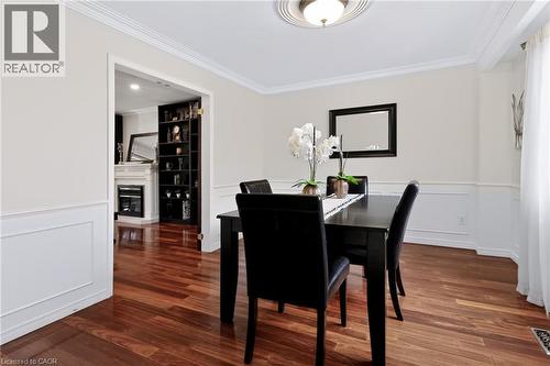 Hardwood flooring throughout, crown molding, chair rail with wainscoting, and an ornate ceiling medallion with a flush-mount light fixture - 4248 Dunvegan Road, Burlington, ON 