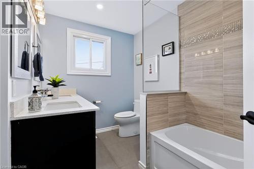 Modern bathroom featuring a sleek black vanity with white quartz countertop and integrated sink, soft-close cabinetry with ample storage, polished chrome fixtures, and a spa-like walk-in shower with w - 4248 Dunvegan Road, Burlington, ON 