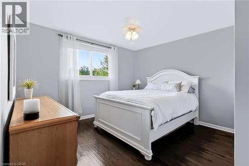 Hardwood-style flooring, light gray wall finish, white window trim, and a semi-flush ceiling light fixture - 4248 Dunvegan Road, Burlington, ON 
